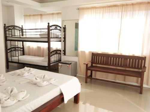 BanguedSorrento hotel resort santa ilocos sur的一间卧室配有两张双层床和一张长凳。