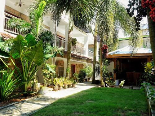 长滩岛Senare Boracay Hotel的棕榈树建筑前的花园