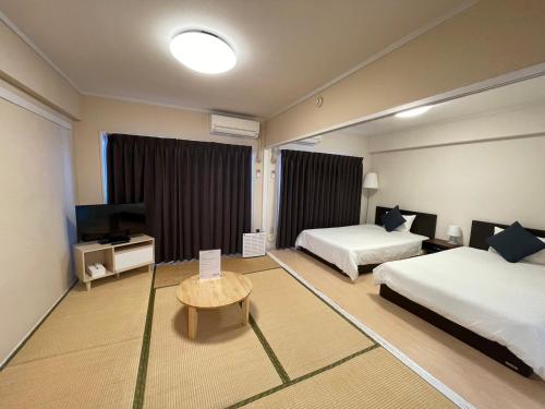 福冈博多入住公寓的酒店客房设有两张床和电视。