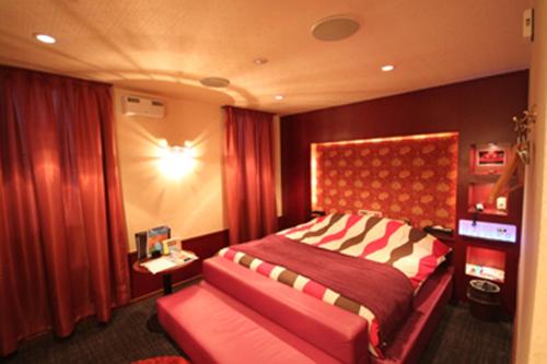 UshikuROOM龍ヶ崎 -Adult only-的一间卧室配有一张大床和红色床头板