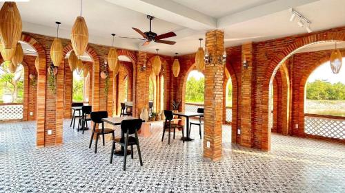 永隆Somo Farm Cửu Long的用餐室设有桌椅和砖墙