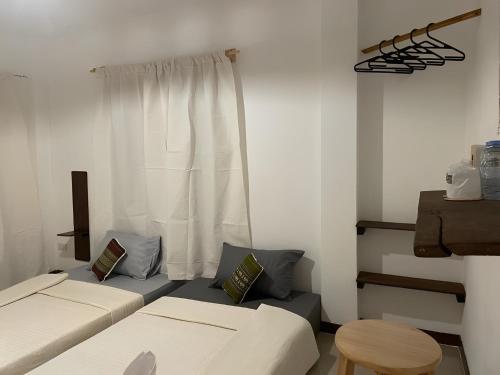 那空拍侬府ดวงใจโฮมเทล Duangjai Hometel的客房设有两张床和窗户。