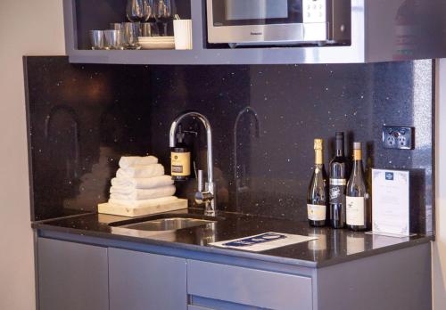 悉尼贝斯沃特精品旅馆 的一个带酒瓶和水槽的厨房台
