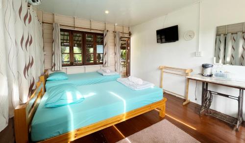 达叻府ครูหนูบ้านพัก แหลมงอบ Krunou baanpak的一间卧室配有蓝色的床和水槽