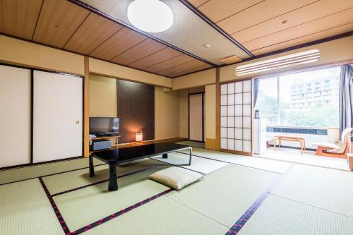 大崎市Ooedo Onsen Monogatari Masuya的客厅配有桌子和电视