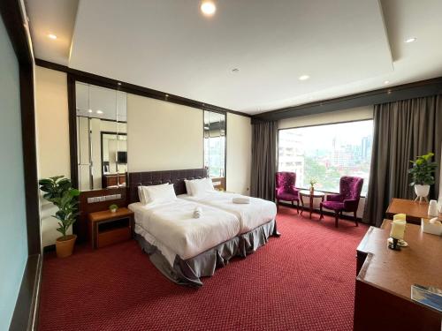 吉隆坡Kingston Hotel Kuala Lumpur的酒店客房设有一张床和一个大窗户