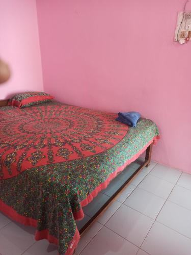 阿姆波尔Om Ganesh Naik Guest House的粉红色客房内的一间卧室,配有一张床