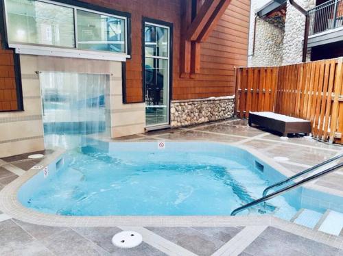 坎莫尔Family Fun- MTN View Stay, Water slide, Pool, Hot Tub, Free Parking的房屋后院的热水浴池