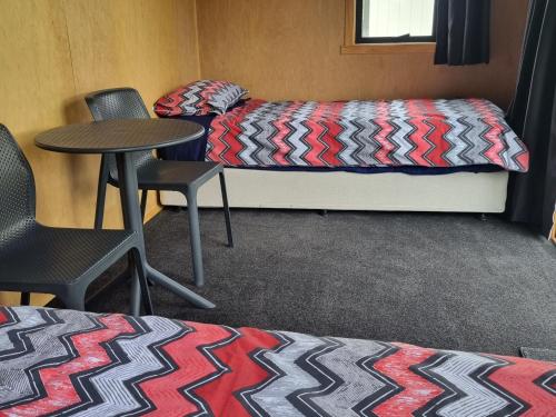 默奇森Murchison Motorhome Park的配有一张床和一张桌子及椅子的房间