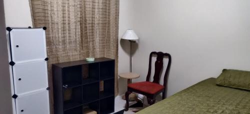蒙特哥贝Guango Grove Cozy Corner的一间卧室配有一张床、梳妆台和椅子