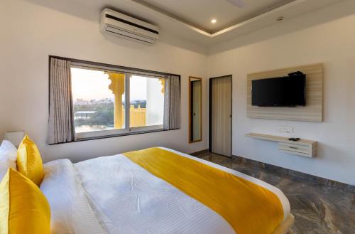 乌代浦Atrangi Hotel & lakeview cafe at PICHOLA LAKE by JD的一间卧室设有一张大床和一台墙上的电视。