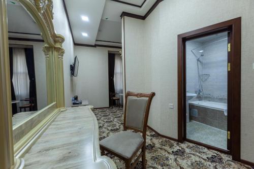 布哈拉Ark Hotel的带浴缸、椅子和浴缸的客房