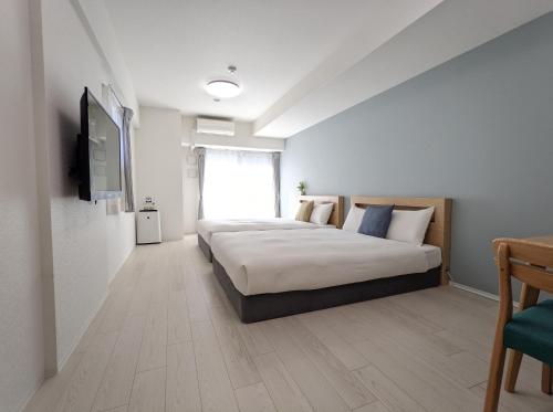 大阪ESLEAD HOTEL Namba South Ⅲ的一间卧室配有一张床和一台平面电视