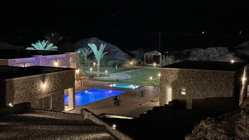 Fulūj Sayghahإستراحة البيت الحجري的享有带游泳池的庭院的夜景