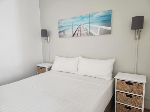 佩雷贝勒佩里阿度假公寓的一间白色卧室,配有床和2个床头柜
