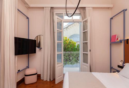 利马索尔Heart Hotel的一间卧室设有一张床和一个滑动玻璃门