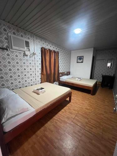 Dalumpinas OesteRedDoorz @ Boondocks Cabins Resort的一间卧室配有两张床和一张桌子