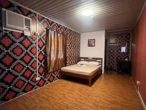 Dalumpinas OesteRedDoorz @ Boondocks Cabins Resort的一间设有床和图案墙的房间