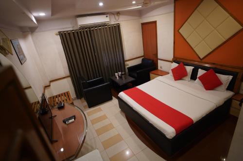 甘德希罕HOTEL GOKUL的配有一张床和一把椅子的酒店客房