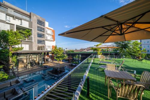 Ban KohongRichmann Resort Hotel Hatyai的一个带椅子和桌子的游泳池以及一把遮阳伞