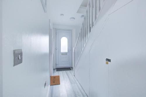 NavestockCrossVille Homes - 7 bed house, 3 baths, 3 parking的一条带白色墙壁和白色门的走廊