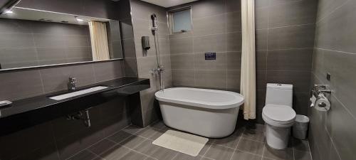 台南大立大饭店的一间带卫生间、水槽和镜子的浴室
