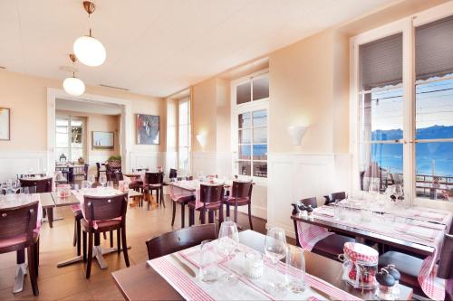 格兰瓦克斯奥伯格火车站酒店的餐厅设有桌椅和窗户。
