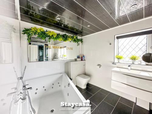 曼彻斯特Beautiful Detached Villa - Jacuzzi Bath - Parking的带浴缸、盥洗盆和卫生间的浴室