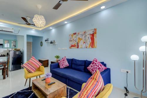 瓦斯科达伽马Coral BnB Premium 2 BHK Apartment - 5 km from Dabolim Airport的客厅配有蓝色的沙发和桌子