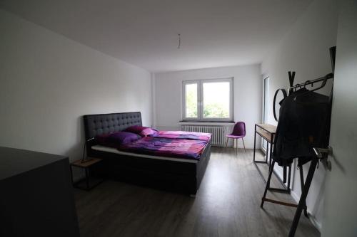 诺伊斯Designer-Apartment near Düsseldorf+Cologne (Apt.3)的一间卧室配有一张床、一张桌子和一台摄像机