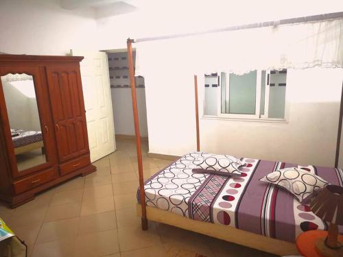 马哈赞加La villa flamboyant的一间卧室配有一张床和一个梳妆台