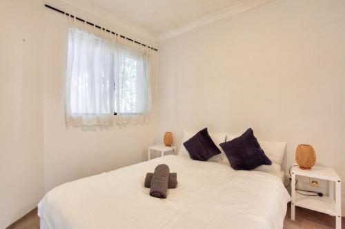 悉尼Cozy 2 Bedroom Apartment Surry Hills的一间白色卧室,配有两张床和窗户