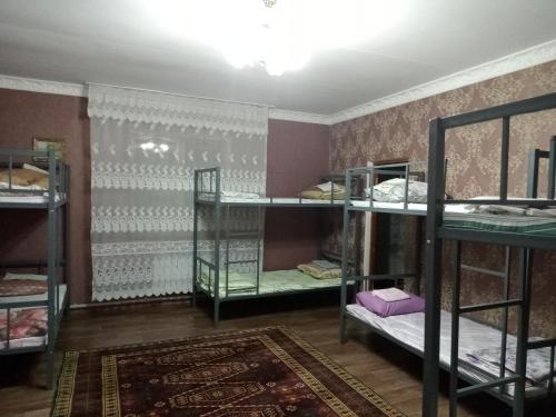 塔拉兹Азия Hotel的带三张双层床和地毯的房间