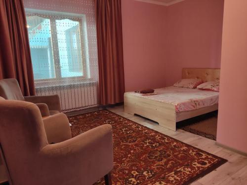 塔拉兹Азия Hotel的一间卧室配有床、椅子和窗户