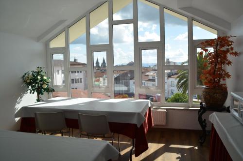圣地亚哥－德孔波斯特拉Loop INN Hostel Santiago de Compostela的大房间设有桌子和大窗户