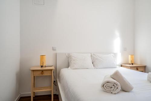 阿尔马达Almada Cityscape Apartment的一间卧室配有白色床和2个床头柜