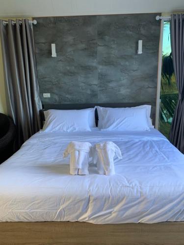 王南安科Baan Suan Madam บ้านสวนมาดามวังน้ำเขียว的床上有两条毛巾