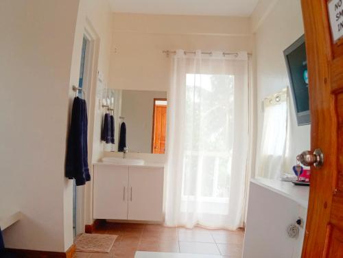 BarasAlon stay的浴室设有白色水槽和镜子