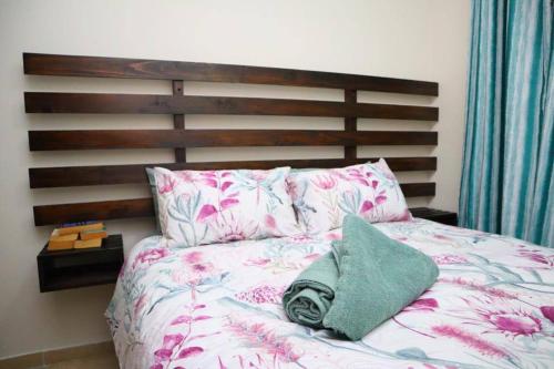 圣卢西亚Manzini Chalet 39的一张带木制床头板和绿色枕头的床
