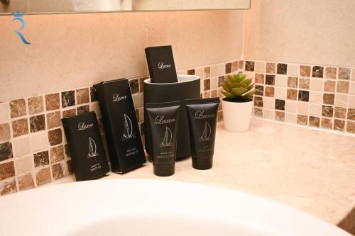 阿布扎比Yas Natura Bliss 1BR Apartment的浴室柜台上放着三瓶黑洗发水