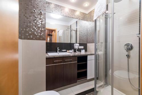 克拉科夫香草公寓式酒店 的带淋浴、卫生间和盥洗盆的浴室