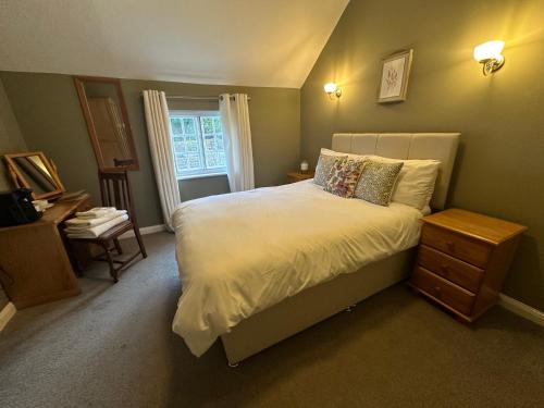牛顿索内The Unicorn Inn的卧室配有白色的床和窗户。
