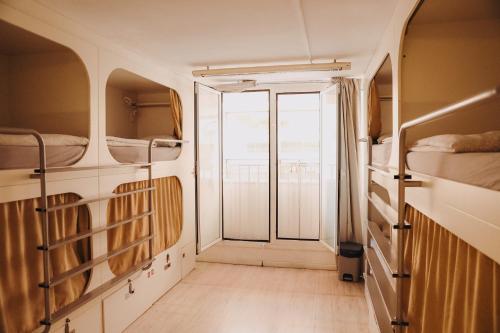 巴塞罗那Onefam Ramblas的客房设有双层床和通往阳台的门。