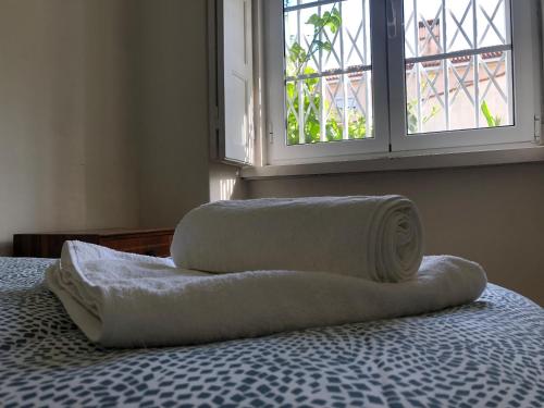 里斯本Casa da Branca Gonta Colaço的床上的两条毛巾,带窗户