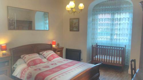 Bellignat阿啦格勒努耶杜汝拉住宿加早餐旅馆的一间卧室配有一张带镜子的床和一张婴儿床