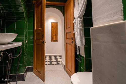 舍夫沙万Riad Dar Chama的浴室设有水槽、卫生间和绿色瓷砖。