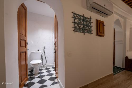 舍夫沙万Riad Dar Chama的一间带卫生间的浴室以及黑白格子地板。