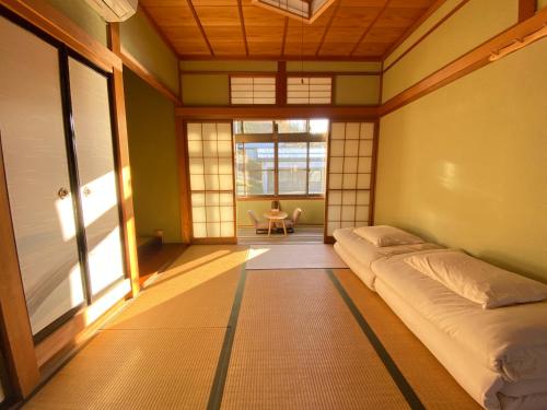 高山Guesthouse Takayama Hanzansha的一间位于客房角落的带一张床的房间