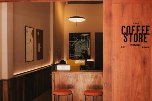 曼谷Cozy Room at The Coffee Store Charoenkrung的柜台上摆放着橘子凳的咖啡店