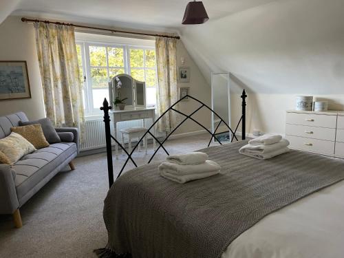 威尔汉姆Cottages at Woodlands, Dormer的一间卧室配有带毛巾的床